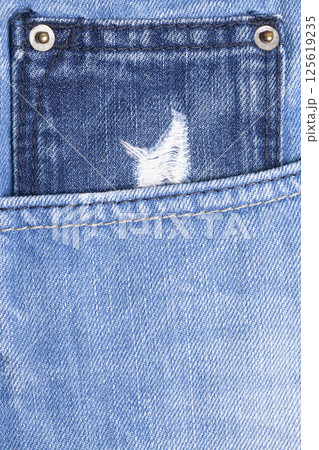 Blue jeans pocket with torn close up Blue jeans pocket with torn close up 125619235