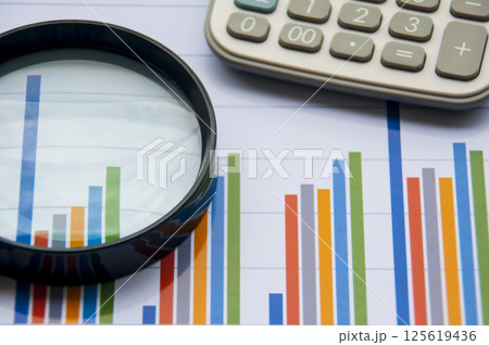 Graph analysis with calculator and magnifying glass. Financial analysis concept 125619436