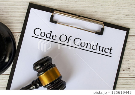 Top view of Code of Conduct text on clipboard with gavel on top. Code of Conduct concept. Top view of Code of Conduct text on clipboard with gavel on top. Code of Conduct concept. 125619443