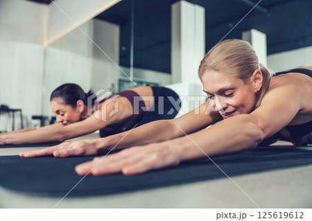 Pretty young women doing yoga and looking relaxed and peaceful Pretty young women doing yoga and looking relaxed and peaceful 125619612