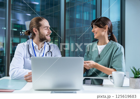 Female practitioner working with msn doctor in clinic using computer to analyze patient data Female practitioner working with msn doctor in clinic using computer to analyze patient data 125619683