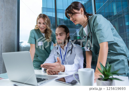 Doctors practitioners in hospital discussing care plan using digital tools 125619693