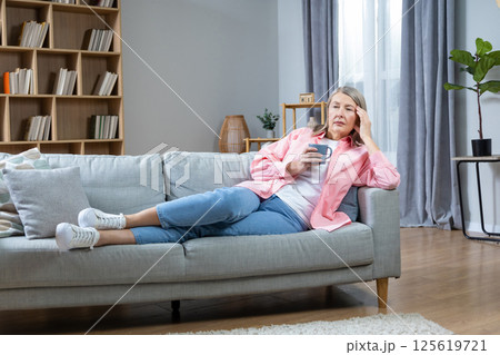 Menopausal woman suffering from a headache and feeling unwell 125619721