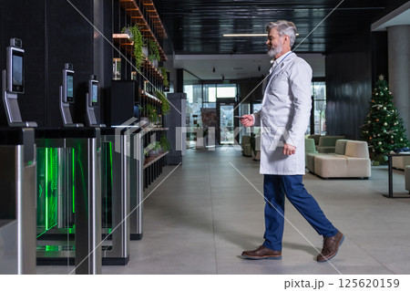 Male doctor going to the security entrance while coming to his working place 125620159