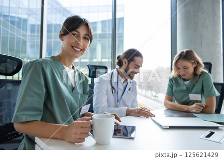 Female doctor in hospital discussing treatment plans with healthcare team 125621429