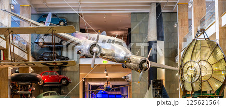 The Lockheed 10a Electra hangs prominently at London's Science Museum, showcasing aviation history amidst various vintage vehicles, creating a captivating visual experience for visitors. 125621564