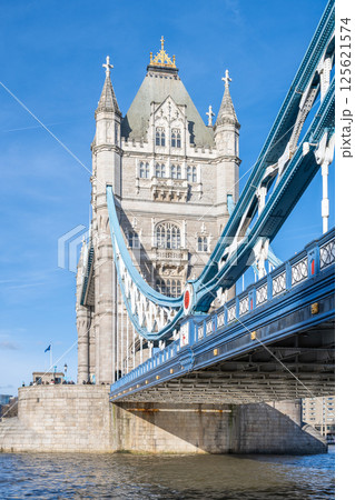 Tower Bridge stands majestically over the River Thames in London, showcasing its iconic architecture under a clear blue sky. The intricate design features both stone and metal elements. Tower Bridge stands majestically over the River Thames in London, showcasing its iconic architecture under a clear blue sky. The intricate design features both stone and metal elements. 125621574