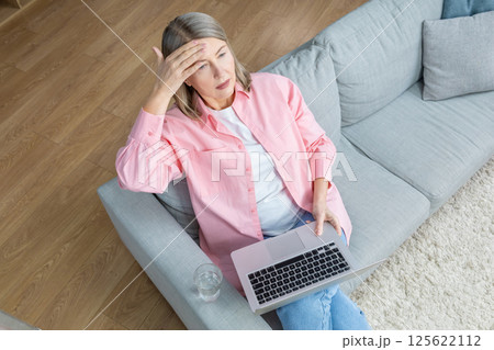 Top view of a woman sitting on the sofa with a laptop 125622112