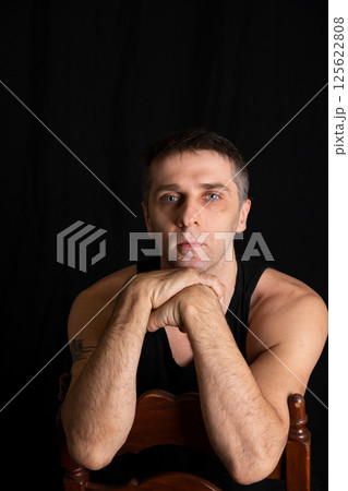 40 years old man in black clothes on black background 125622808