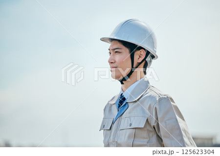 遠くを見つめる作業着姿の20代の若い男性 遠くを見つめる作業着姿の20代の若い男性 125623304