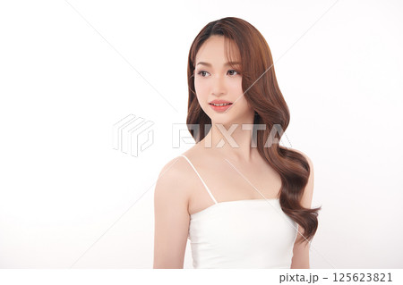 A beautiful young Asian woman with clean, fresh skin against a white background. Skincare, facial treatment, cosmetology, beauty, and spa. An elegant portrait of an Asian woman. 125623821