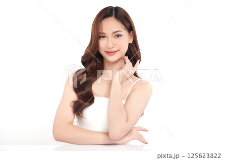 A beautiful young Asian woman with clean, fresh skin against a white background. Skincare, facial treatment, cosmetology, beauty, and spa. An elegant portrait of an Asian woman. 125623822