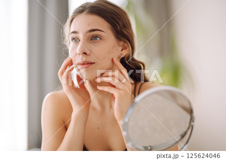 Woman worry about her face when she saw the problem of acne occur by a mini mirror. Pimples, acne Woman worry about her face when she saw the problem of acne occur by a mini mirror. Pimples, acne 125624046
