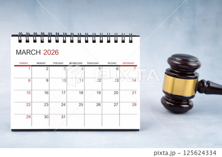 March 2026 desk calendar with judge's gavel on worktable. March 2026 desk calendar with judge's gavel on worktable. 125624334