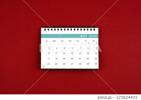 May 2026 desk calendar on red background in the middle top view. May 2026 desk calendar on red background in the middle top view. 125624435