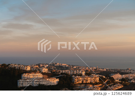 Golden hour light over Mediterranean hillside town in Costa del Sol 125624689