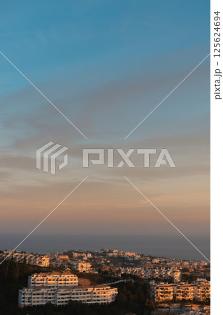Golden hour light over Mediterranean hillside town in Costa del Sol 125624694