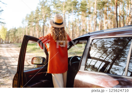 Stopping during a car trip. Young woman enjoying nature. Journey by car. Lifestyle, travel, tourism 125624710