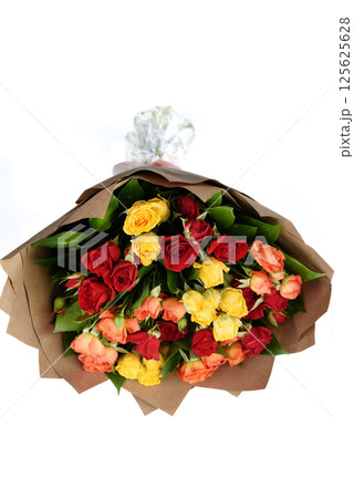 A bouquet of multi-colored roses packed in brown thick paper on a white background. A bouquet of multi-colored roses packed in brown thick paper on a white background. 125625628