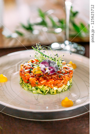 Portion of layered salad with salmon and cucumber 125625712