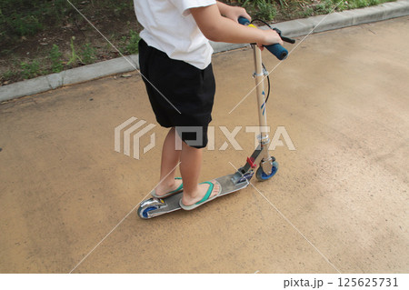 草履でキックスクーターに乗る子供(7歳児/男の子) 草履でキックスクーターに乗る子供(7歳児/男の子) 125625731