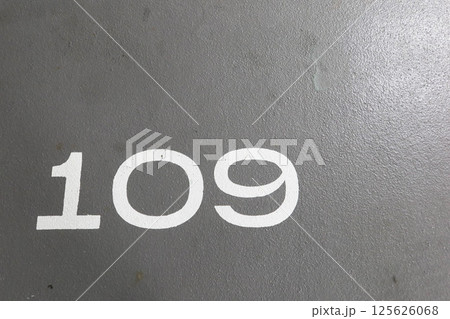 close up of number 109 painted in white on the grey ground with copy space close up of number 109 painted in white on the grey ground with copy space 125626068