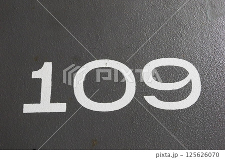 close up of number 109 painted in white on the grey ground with copy space close up of number 109 painted in white on the grey ground with copy space 125626070