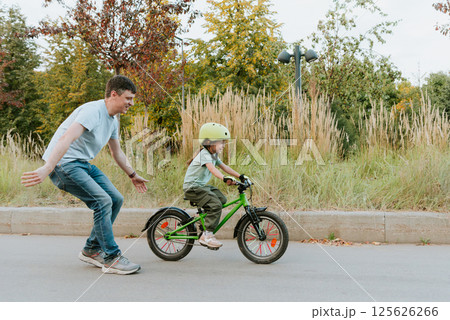 Quality Time Together Father Teaching Daughter to Ride a Bike Outdoors 125626266