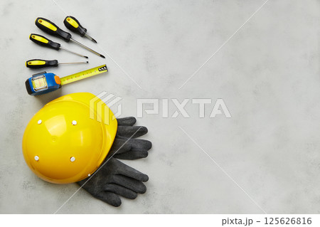 Happy labor day concept. Construction tools, yellow helmet on dark wooden background Happy labor day concept. Construction tools, yellow helmet on dark wooden background 125626816