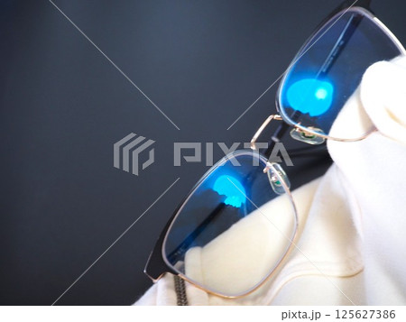 眼鏡を裾で拭く写真（右） 125627386