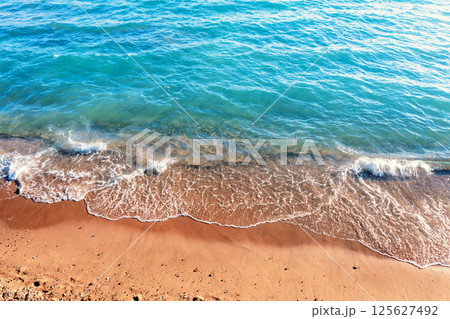 Waves roll on the sandy beach. Natural background Waves roll on the sandy beach. Natural background 125627492