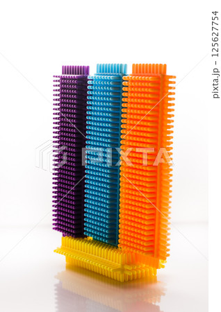 Three colored parts of a children's construction set on a white background. Puzzle for young childre. 125627754