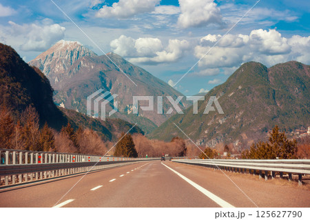 View of beautiful mountain landscape through the windscreen on a sunny day. Driving a car on mountain winding road in National park Picos de Europa. Cantabria, Spain, Europe View of beautiful mountain landscape through the windscreen on a sunny day. Driving a car on mountain winding road in National park Picos de Europa. Cantabria, Spain, Europe 125627790