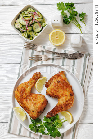 roast chicken legs with crispy skin on a plate 125628548
