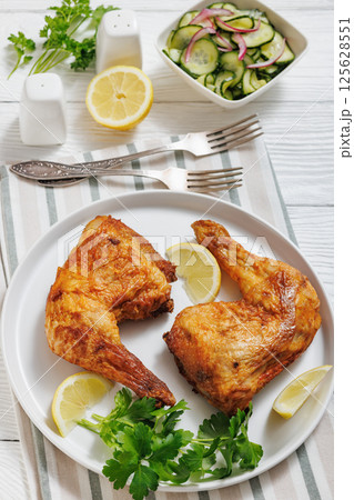 roast chicken legs with crispy skin on a plate 125628551
