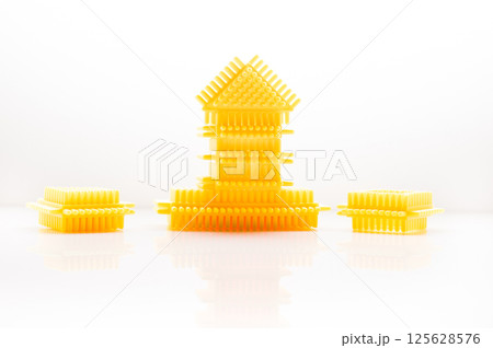 The elements of the children's construction toy harmonize well with the background color. The plastic building blocks of the play set attract with their shape and color.  125628576