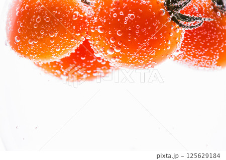 A black-and-white photo showing a glass with a long stem containing a carbonated drink. 125629184