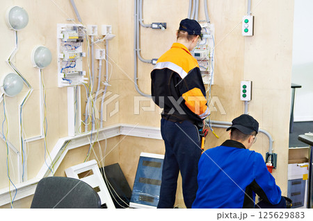 Electrician makes wiring for lighting 125629883