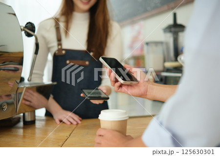 Customer making digital payment at coffee shop using smartphone. Customer making digital payment at coffee shop using smartphone. 125630301