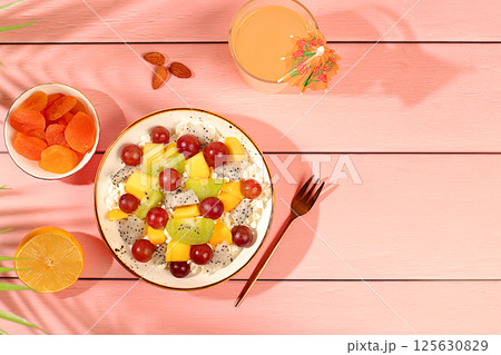Fruit salad with soft grain cottage cheese, yogurt, dragon fruit, kiwi, mango, oranges, nuts, grapes and juice, Healthy light breakfast with ingredients. Diet healthy lifestyle advertisement Fruit salad with soft grain cottage cheese, yogurt, dragon fruit, kiwi, mango, oranges, nuts, grapes and juice, Healthy light breakfast with ingredients. Diet healthy lifestyle advertisement 125630829