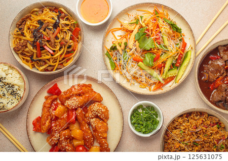 Variety of Chinese food dishes top view on table with chopsticks, light beige background, cuisine of China Variety of Chinese food dishes top view on table with chopsticks, light beige background, cuisine of China 125631075