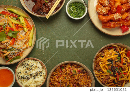 Variety of Chinese food dishes top view on table with chopsticks forming a frame with space for text, rustic green background, cuisine of China Variety of Chinese food dishes top view on table with chopsticks forming a frame with space for text, rustic green background, cuisine of China 125631081