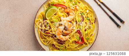 Pad thai noodles with shrimps, peanuts and lime on a plate, traditional dish of Thailand Pad thai noodles with shrimps, peanuts and lime on a plate, traditional dish of Thailand 125631088