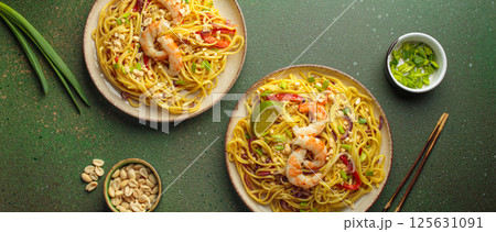Two plates of thai noodles with shrimp and peanuts on green background, dish of Thailand 125631091