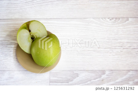 Apples on a light background. A green apple, half or slice of a green apple Apples on a light background. A green apple, half or slice of a green apple 125631292