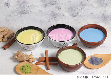 An assortment of colorful latte Japanese tea, matcha green, blue, pink moon milk, golden milk, ginger and cinnamon, top view. A fashionable healthy drink has anti-inflammatory properties. 125631551