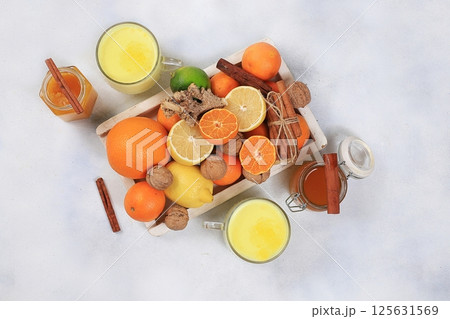 Traditional turmeric latte with ginger root, cinnamon sticks, honey and citrus fruits. Alternative medicine concept, anti-inflammatory, anti-virus, selective focus 125631569