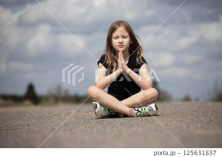 Little beautiful girl praying in nature. Hands folded in prayer. Religion concept Little beautiful girl praying in nature. Hands folded in prayer. Religion concept 125631837