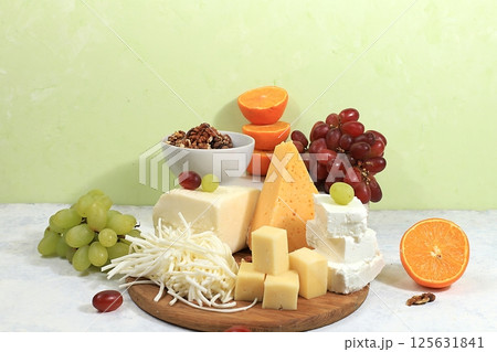 Assortment of different varieties of cheeses, grapes and nuts, fruits, the basis of the French diet, healthy and natural food selection, advertising card or invitation to a cafe, shop, menu, selective 125631841