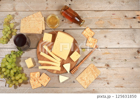 Assortment of different varieties of cheese, red wine, grapes and cracker, the basis of the French diet, healthy and natural food selection, advertising card or invitation to a cafe, shop, menu, 125631850